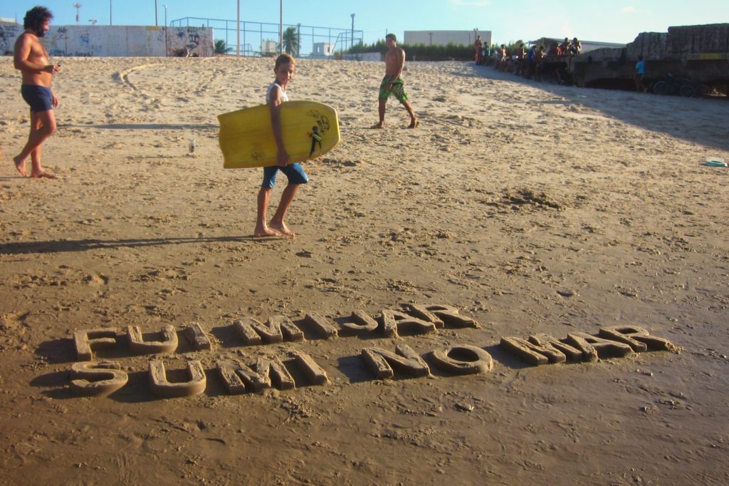 FUI MIJAR SUMI NO MAR - BLOCK LETTER. Texto moldado na areia da praia.